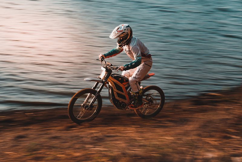 Rider at the shore on an electric dirt bike